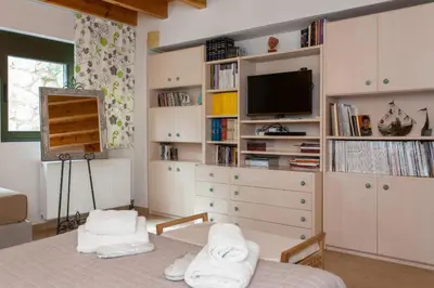 a bedroom with a bed and a tv and a dresser at Aoria Villa By Hope Estate in Arménoi