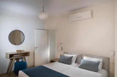 a bedroom with a bed and a table and a mirror at C&M Residence Chania Old Town in Chania Town