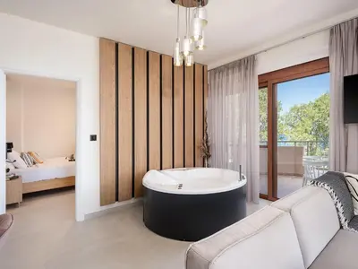 a living room with a tub and a bedroom at Elia Seaside in Chania Town