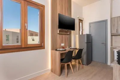 a kitchen with a table with chairs and a refrigerator at Porto Orion Studios in Chania Town