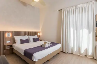 a bedroom with a bed and a large window at Porto Orion Studios in Chania Town