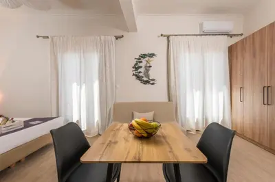 a dining room table with chairs and a bowl of fruit on it at Porto Orion Studios in Chania Town