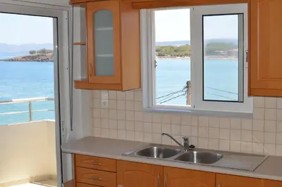 a kitchen with a sink and two windows at Kalamaki Apartments in Kalamaki Chanion