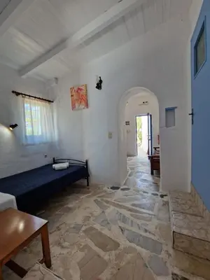 a living room with a blue bed in a white wall at Iliana's Bungalow in Arménoi
