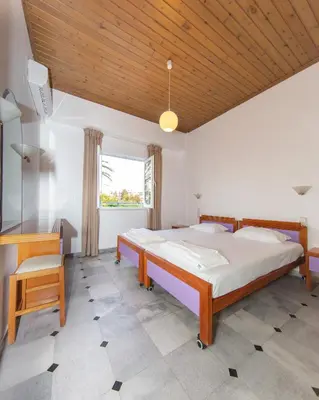 a bedroom with a large bed and a window at Manias Hotel Apartments in Agia Marina Nea Kydonias