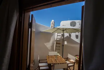 a balcony with a table and an umbrella at Horizon Deluxe House in Chania Town
