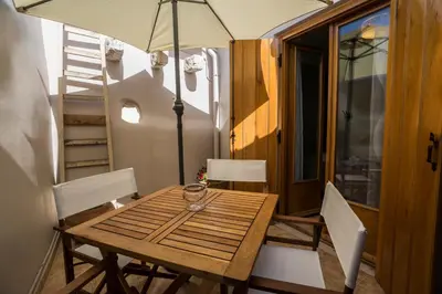a wooden table and chairs with an umbrella in a room at Horizon Deluxe House in Chania Town