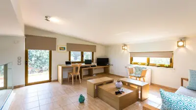 a living room with a couch and a table at Villa Staride, sea view, private heated pool, playground in Païdhokhórion