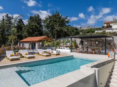 a swimming pool with lounge chairs and a table at Villa Staride, sea view, private heated pool, playground in Païdhokhórion