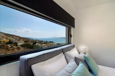 a room with a large window and a couch with pillows at Seametry Luxury Living Apartments ADULTS ONLY in Souda