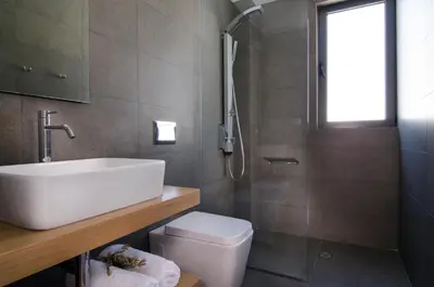 a bathroom with a sink and a toilet and a shower at Seametry Luxury Living Apartments ADULTS ONLY in Souda