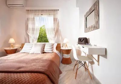 a bedroom with a bed and a desk and a window at Villa Vanelia Mare in Kalamaki Chanion