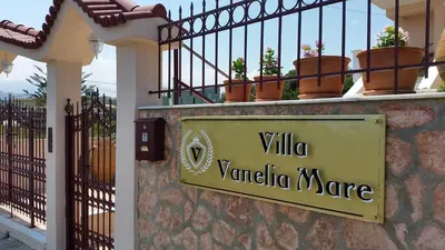 a sign on a wall with potted plants on a balcony at Villa Vanelia Mare in Kalamaki Chanion