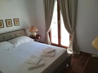 a bedroom with a bed with two towels on it at Ktima Grammeno Beachside Villa in Palaiochóra