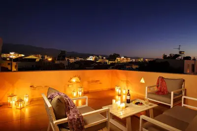 a balcony with a table and chairs and candles at Odyssey Studios in Chania Town