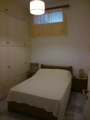 a bedroom with a white bed and a window at Panoramic Seaview Holiday House in Souda
