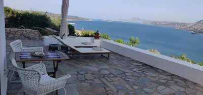 a patio with a table and chairs and the ocean at Panoramic Seaview Holiday House in Souda