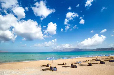 a beach with umbrellas and chairs and the ocean at Galini Beach Hotel in Kissamos