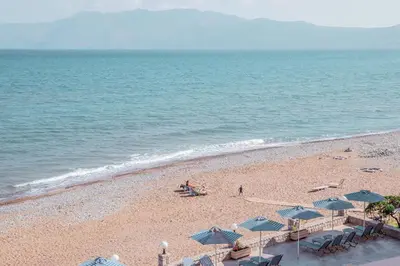 a beach with chairs and umbrellas and the ocean at Galini Beach Hotel in Kissamos