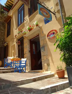 a building with blue chairs in front of a door at Anemones Rooms in Chania Town