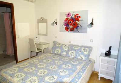 a bedroom with a bed and a desk and a painting on the wall at Anemones Rooms in Chania Town