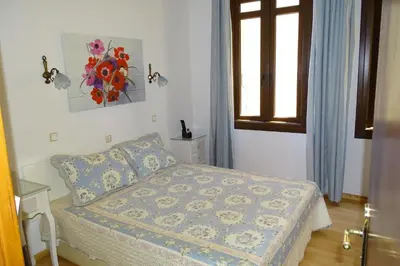 a small bedroom with a bed and a window at Anemones Rooms in Chania Town