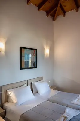 a bedroom with two beds and a picture on the wall at Androulakis Apartments in Gerani Chanion
