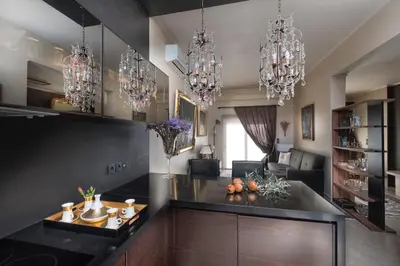a kitchen with chandeliers and a living room at Golden View Villa in Kato Daratso