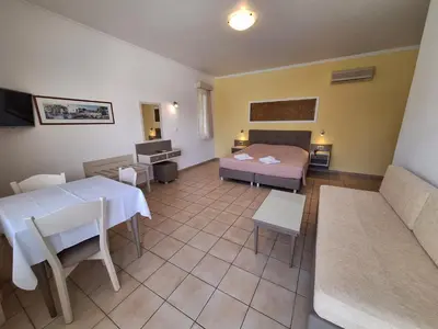 a room with a bed and a table and a couch at Perla Beach in Agia Marina Nea Kydonias