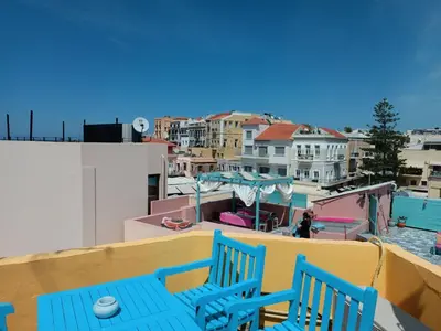 a balcony with two blue chairs and a pool at Imeros in Chania Town