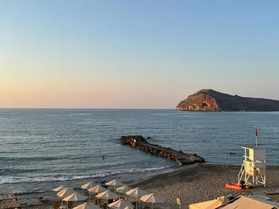 a beach with a bunch of umbrellas and the ocean at Τhe Noverian Antama Organic Beach Resort Chania with Outdoor Heated Pool in Agia Marina Nea Kydonias
