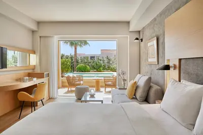 a bedroom with a bed and a living room at Minoa Palace Resort in Plataniás