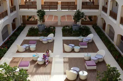 a woman sitting on a bench in a building at Minoa Palace Resort in Plataniás