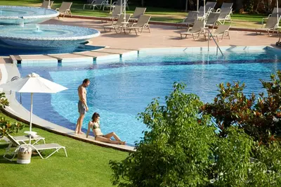 a man and a woman sitting in a swimming pool at Minoa Palace Resort in Plataniás