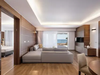 a living room with a couch and a television at Minoa Palace Resort in Plataniás