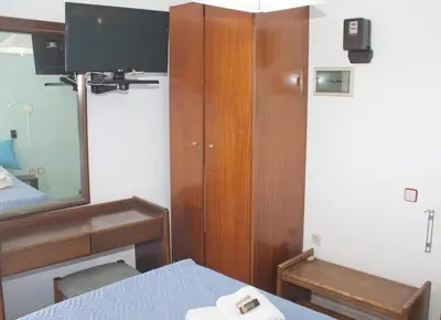 a bedroom with a bed and a mirror and a tv at Melani Apartments in Chania Town