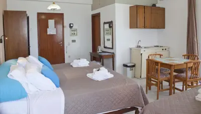 a hotel room with two beds and a table at Melani Apartments in Chania Town