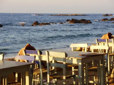 a group of tables and chairs on the beach at Melani Apartments in Chania Town