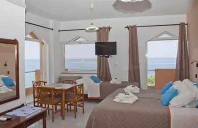 a hotel room with two beds and a table and chairs at Melani Apartments in Chania Town