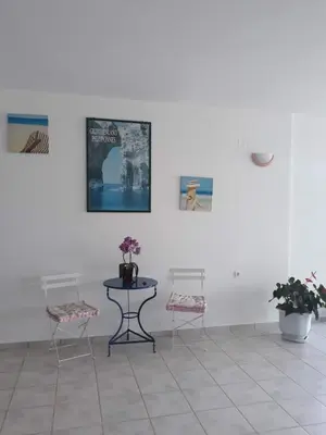 a room with two chairs and a table and some pictures at Kalliopi Studios - Apartments in Kato Daratso