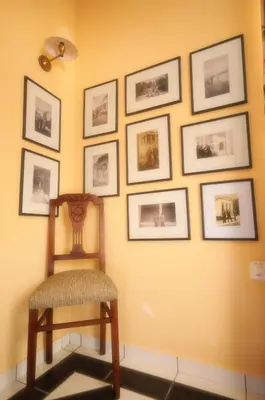 a chair sitting in front of a wall with pictures at Metohi Georgila in Maleme