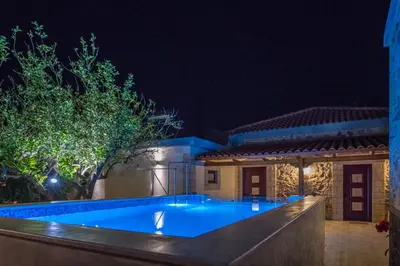 a swimming pool in front of a house at night at PRIVATE Sapphiros Villa in Kissamos