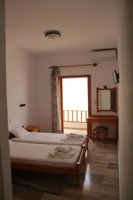 a hotel room with two beds and a window at Hotel Alkyon in Khóra Sfakíon