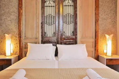 a bedroom with a white bed with two lamps at Elia Kounoupidiana Apartment in Kounoupidhianá