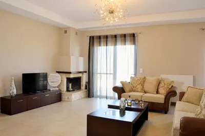 a living room with a couch and a tv at Elia Kounoupidiana Apartment in Kounoupidhianá