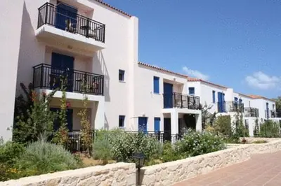 a large white building with balconies on a street at Margarita Beach Hotel in Agia Marina Nea Kydonias