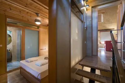 a small bedroom with a bed and a mirror at Neoria Houses in Chania Town