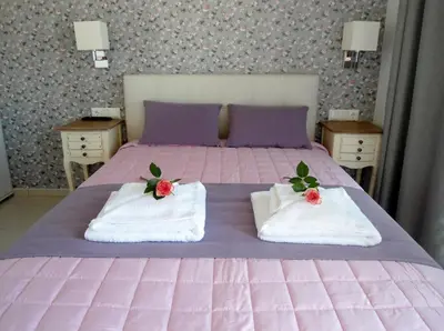 a pink bed with towels on top of it at Petrakis sunset in Palaiochóra