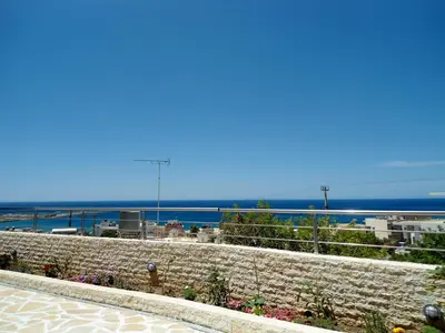 a stone wall with a view of the ocean at Petrakis sunset in Palaiochóra