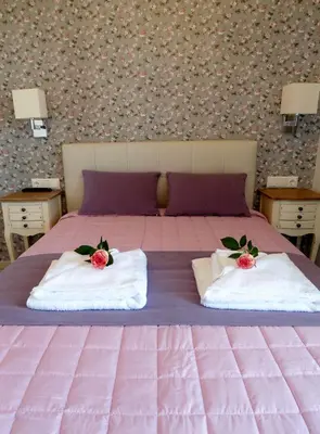 a pink bed with two pillows on top of it at Petrakis sunset in Palaiochóra